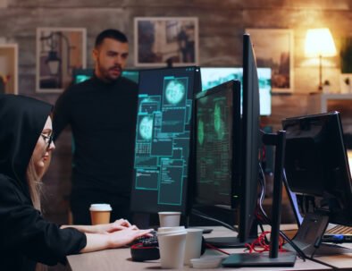 Girl hacker wearing glasses and a hoodie while stealing personal data with her team.